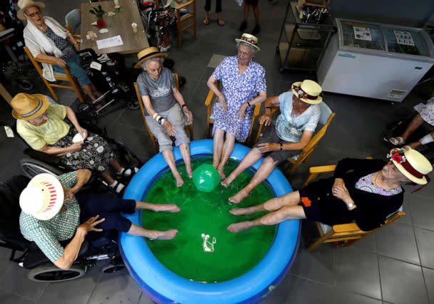 PHOTO: Residents at the Ter Biest house for the elderly dip their feet in a pool as a heatwave hits Europe, in Grimbergen, Belgium on July 19, 2022. (Yves Herman/Reuters)