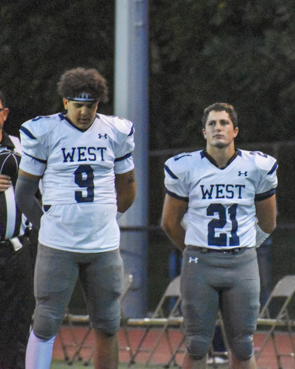 Pocono Mountain West football players Isaiah Armand (No. 9) and Matt Marinovich (No. 21) stand for the national anthem before their game at Stroudsburg on Friday, Sept. 24, 2021.