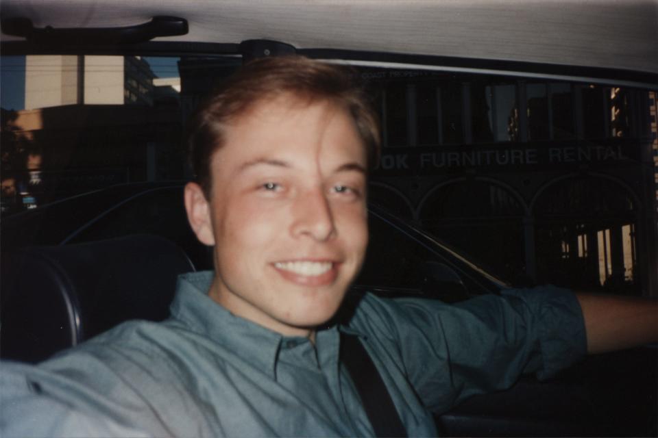 Elon Musk seated and smiling in his BMW in the summer of 1995.