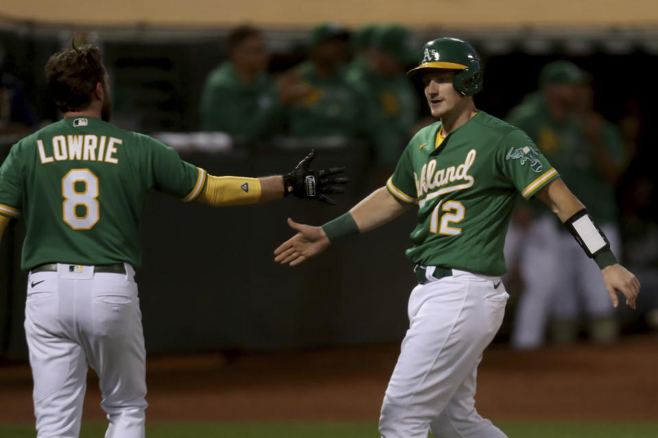 Oakland Athletics' Sean Murphy, right, is congratulated by Jed Lowrie, left, after both scored on a double by Elvis Andrus against the Los Angeles Angels during the sixth inning of a baseball game in Oakland, Calif., Tuesday, June 15, 2021. (AP Photo/Jed Jacobsohn)