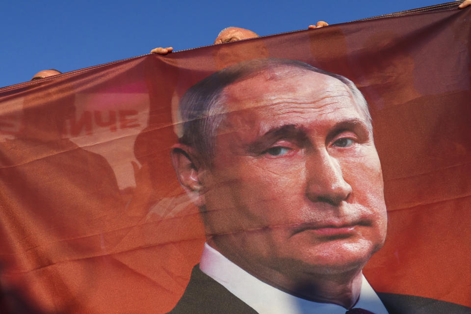 Protesters hold a flag depicting Russian President Vladimir Putin during a rally supporting Milorad Dodik, pro-Russian leader in Bosnia, in Lukavica, Bosnia, Friday, Sept. 1, 2023. Several hundreds of Serb supporters of Milorad Dodik, pro-Russian leader in Bosnia have gathered at several entity lines in Bosnia, demanding a stop to what they call illegal criminal persecution of their leadership by state prosecution. Carrying Russian flags with pictures of Russian president Putin, Serbs demanded that Bosnian state prosecution removes its indictment against Dodik which is accused of defying the decisions by international peace agreement over-seer Christian Schmidt. (AP Photo)