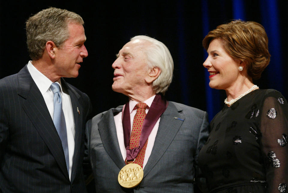 FILE - This April 22, 2002 file photo shows President Bush, left, with actor Kirk Douglas, center, as first lady Laura Bush, right, looks on during the National Endowment for the Arts National Medal of Arts Awards ceremony in Washington. Douglas died Wednesday, Feb. 5, 2020 at age 103. (AP Photo/Pablo Martinez Monsivais, File)