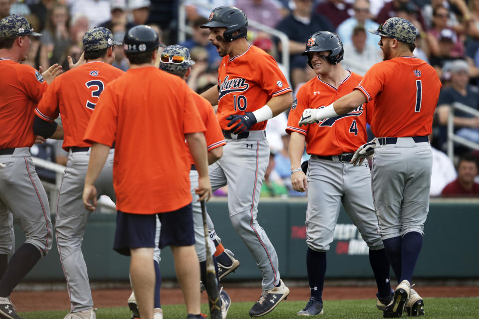 Auburn's Edouard Julien (10) celebrates his two-run home run against Mississippi State in the second inning of an NCAA College World Series baseball game in Omaha, Neb., Sunday, June 16, 2019. Rankin Woley also scored on the play. (AP Photo/Nati Harnik)