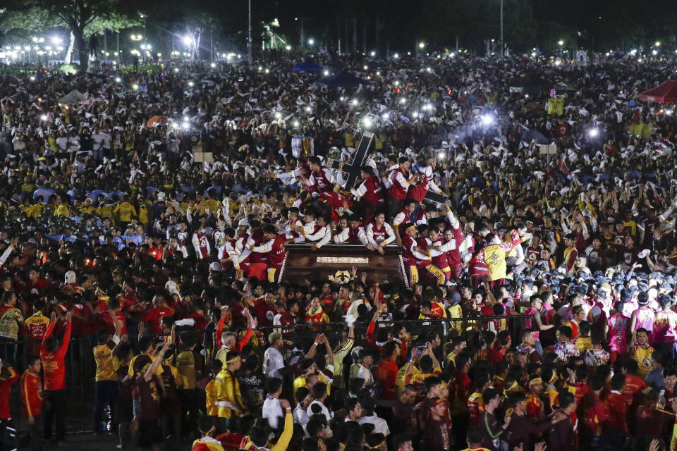 A crowd of Filipino Roman Catholic devotees follow the carriage of the Black Nazarene during a raucous procession to celebrate its feast day Thursday, Jan. 9, 2020, in Manila, Philippines. A mammoth crowd of mostly barefoot Filipino Catholics prayed for peace in the increasingly volatile Middle East at the start Thursday of an annual procession of a centuries-old black statue of Jesus Christ in one of Asia's biggest religious events. (AP Photo/Aaron Favila)