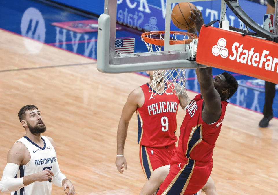 New Orleans Pelicans forward Zion Williamson (1) dunks as Memphis Grizzlies center Jonas Valanciunas (17) watches during the first quarter of an NBA basketball game in New Orleans, Saturday, Feb. 6, 2021. (AP Photo/Derick Hingle)