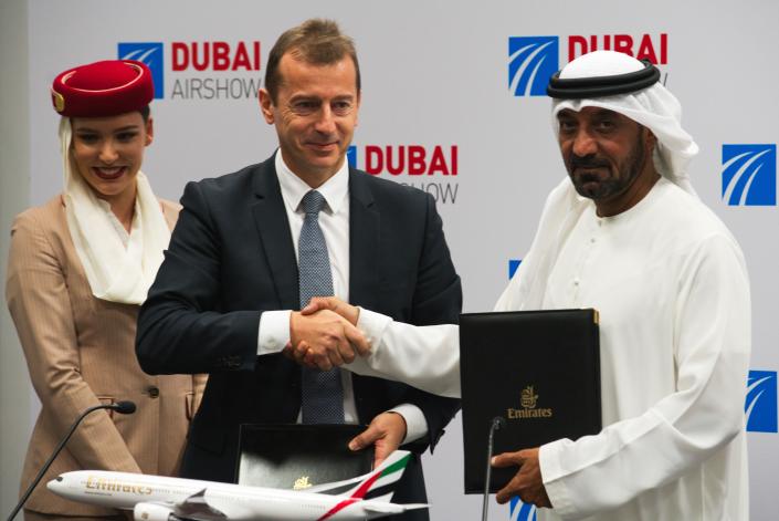 Airbus CEO Guillaume Faury, center, shakes hands with Sheikh Ahmed bin Saeed Al Maktoum, the chairman and CEO of the Dubai-based long-haul carrier Emirates, at the Dubai Airshow in Dubai, United Arab Emirates, Monday, Nov. 18, 2019. The Dubai-based airline Emirates announced Monday a new order for 20 additional wide-body Airbus A350-900 planes in a deal worth $6.4 billion. This brings the airline's total order for the aircraft to 50 Airbus A350s costing $16 billion at list price. (AP Photo/Jon Gambrell)