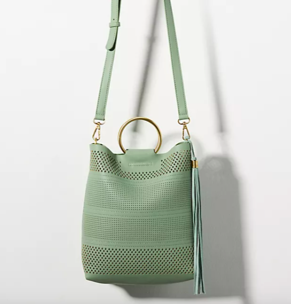 Perforated crossbody Bag with gold Ring Handle in green. Image via Anthropologie.