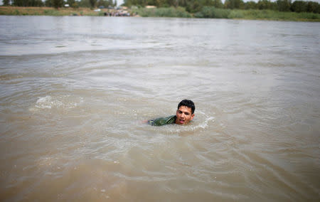 An Iraqi swims in the Tigris River after the bridge has been temporarily closed, in western Mosul, Iraq May 6, 2017. REUTERS/Suhaib Salem