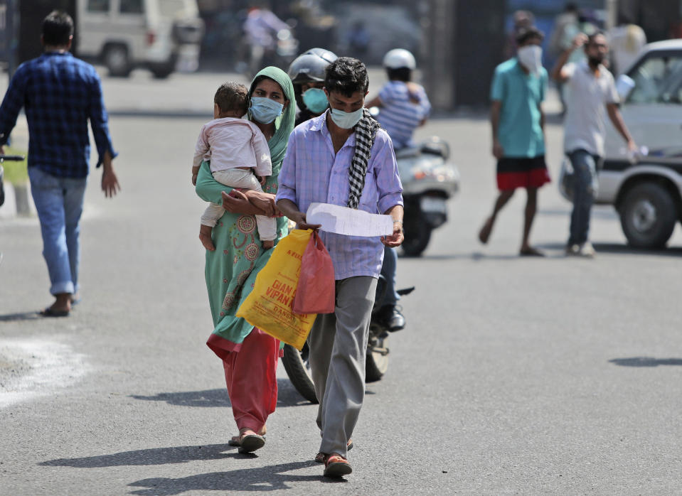 People wearing face masks as a precaution against the coronavirus walk outside a government hospital in Jammu, India, Saturday, Sept. 19, 2020. India's coronavirus cases are now the second-highest in the world and only behind the United States. (AP Photo/Channi Anand)