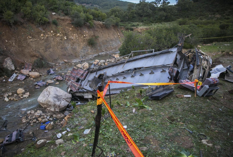 The debris of a regional bus that crashed off a hill are pictured Sunday Dec.1, 2019, causing the death of at least 22 local passengers who were on an excursion in the Amdoun region, northern Tunisia. The bus, which belonged to a private local company, veered of a winding road after the driver failed to maneuver a sharp turn and crashed at the bottom of a ravine. (AP Photo/Riadh Dridi)