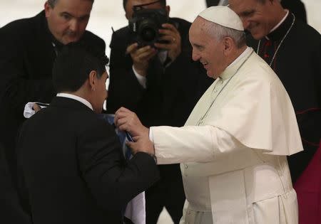 Former soccer star Diego Maradona (L) presents Pope Francis with an Argentina national soccer jersey during a special audience held before a special interreligious "Match for Peace", at the Paul VI hall at the Vatican September 1, 2014. REUTERS/Alessandro Bianchi
