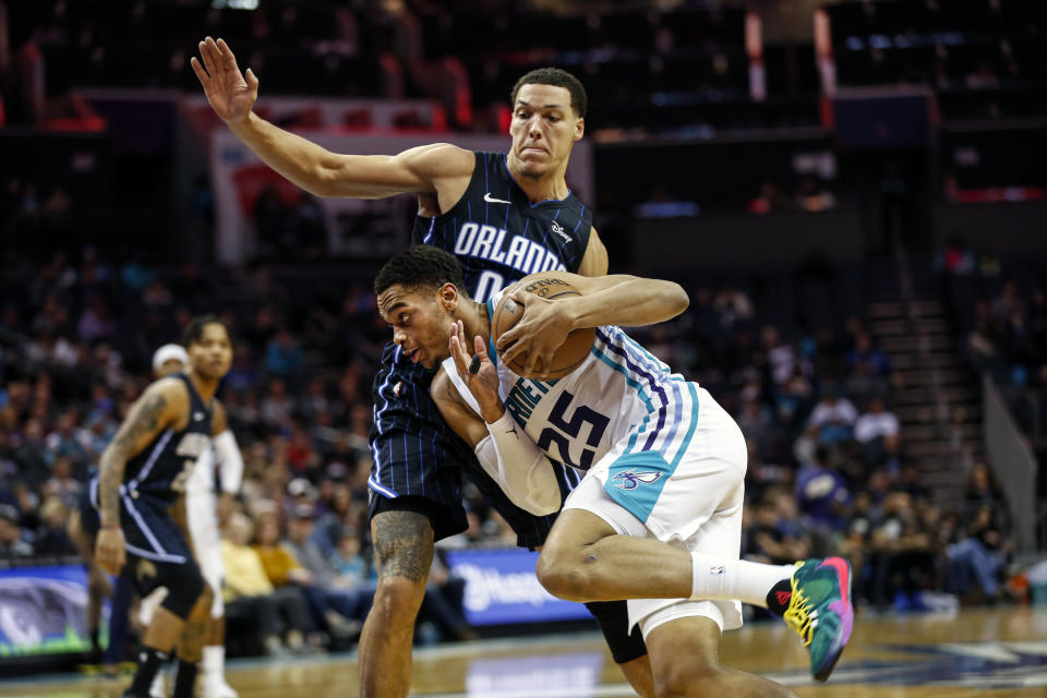 Charlotte Hornets forward P.J. Washington (25) drives into Orlando Magic forward Aaron Gordon in the first half of an NBA basketball game in Charlotte, N.C., Monday, Jan. 20, 2020. (AP Photo/Nell Redmond)