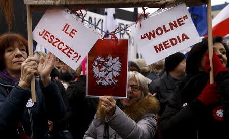 People gather during an anti-government demonstration for free media in front of the Polish television building in Warsaw, January 9, 2016. The placards read "How many more?" (L) and "Free Media". REUTERS/Kacper Pempel