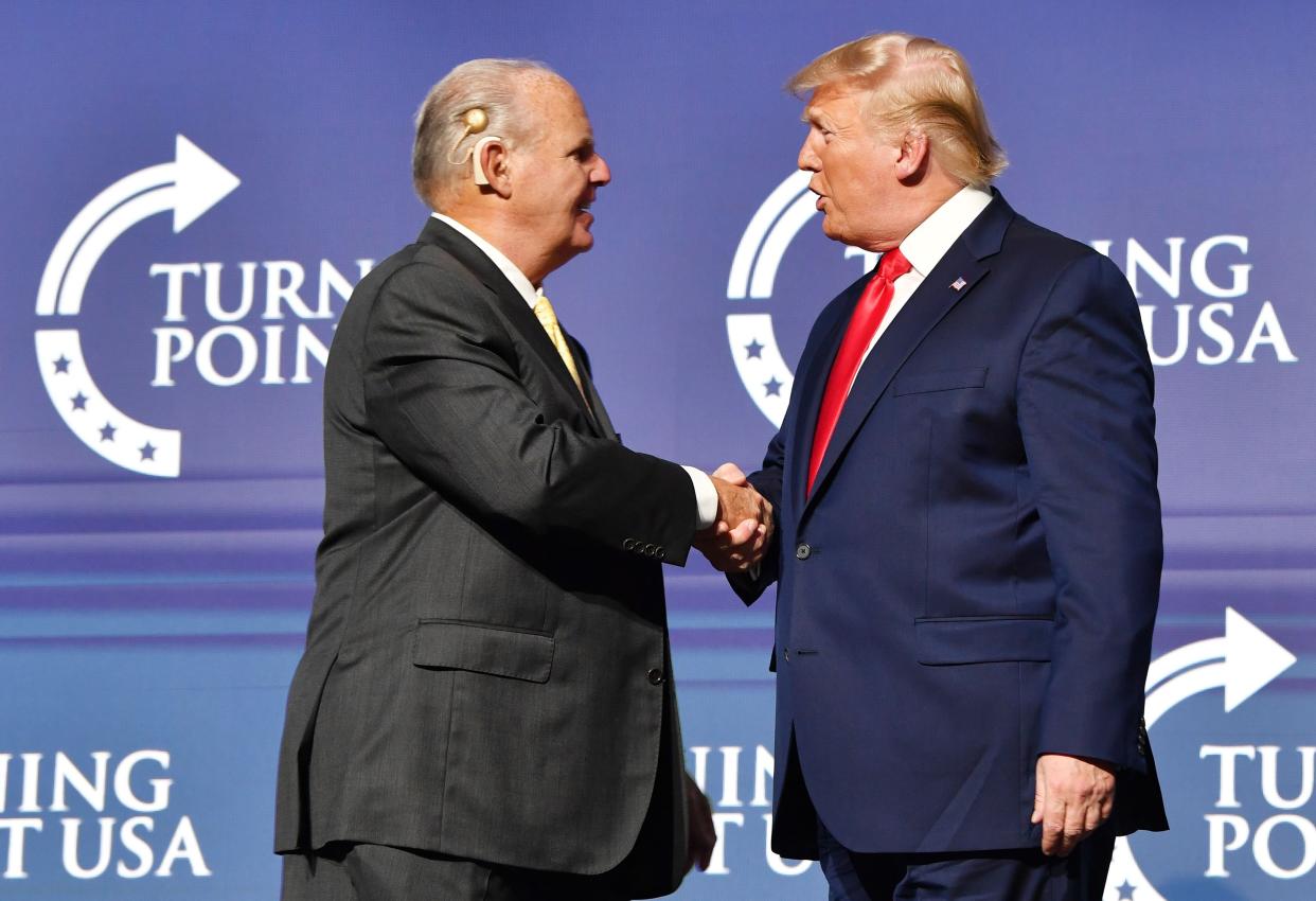 Rush Limbaugh shakes hands with President Donald Trump during the Turning Point USA Student Action Summit in West Palm Beach, Fla., in December 2019. (Photo by Nicholas Kamm/AFP via Getty Images)