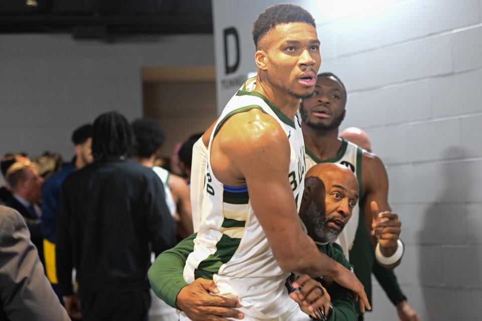 Dec 13, 2023; Milwaukee, Wisconsin, USA; Milwaukee Bucks forward Giannis Antetokounmpo (34) is restrained by a coach outside the Indiana Pacers locker room after the game at Fiserv Forum. Mandatory Credit: Benny Sieu-USA TODAY Sports