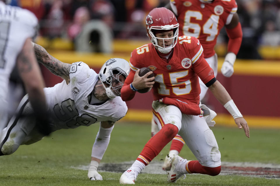 Kansas City Chiefs quarterback Patrick Mahomes (15) struggles for yardage as Las Vegas Raiders defensive end Maxx Crosby (98) defends during the second half of an NFL football game Monday, Dec. 25, 2023, in Kansas City, Mo. (AP Photo/Charlie Riedel)