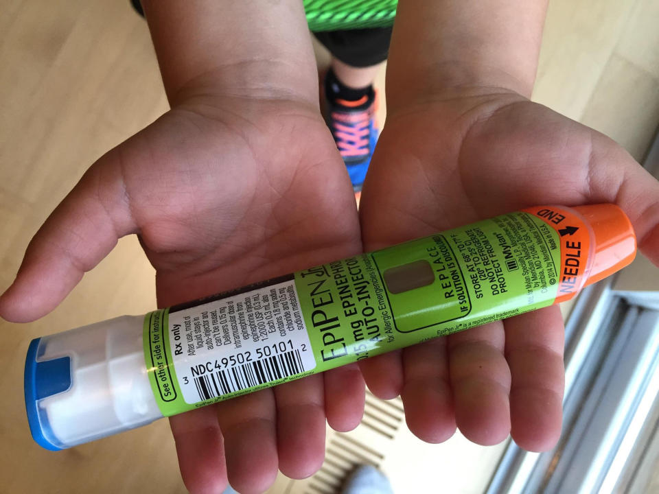 A child holding an EpiPen