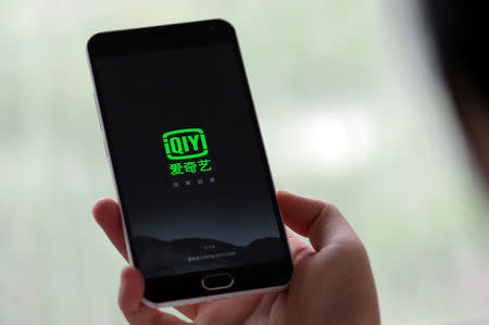 FILE PHOTO: A person holds a phone with Baidu Inc's video streaming service iQiyi in Jinan, Shandong province, China, in this May 25, 2016 photo illustration. REUTERS/Stringer/File Photo