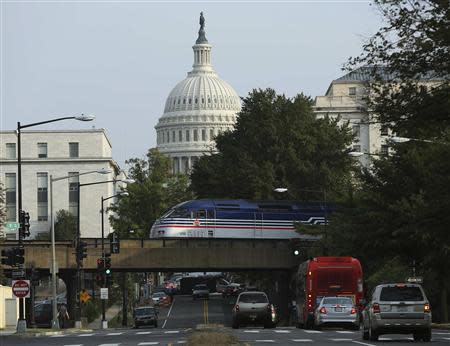 Light traffic and a Virginia Railway Express commuter train pass by the U.S. Capitol during day three of the U.S. government shutdown in Washington October 3, 2013. REUTERS/Gary Cameron