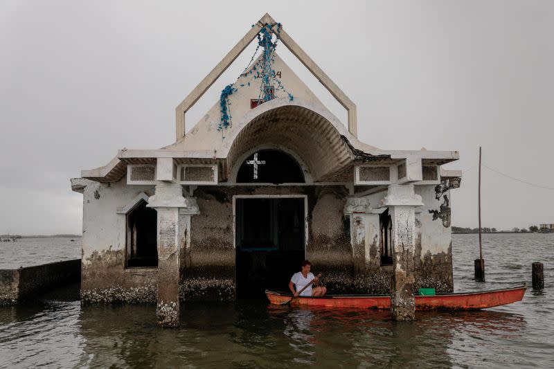 The Wider Image: Rising seas threaten early end for sinking village in Philippines