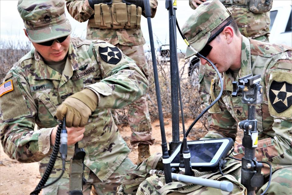 Soldiers setting up portable packs.