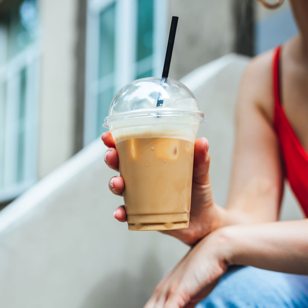 woman drinking iced coffee outside