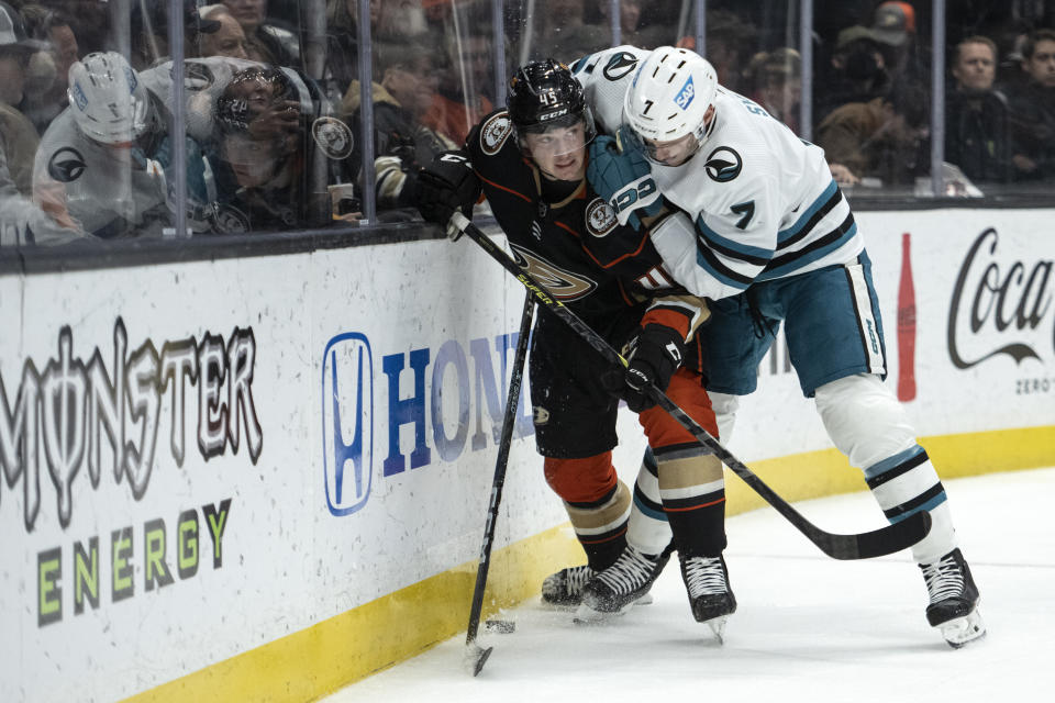 Anaheim Ducks defenseman Colton White (45) protects the puck from San Jose Sharks center Nico Sturm (7) during the second period of an NHL hockey game in Anaheim, Calif., Friday, Jan. 6, 2023. (AP Photo/Kyusung Gong)