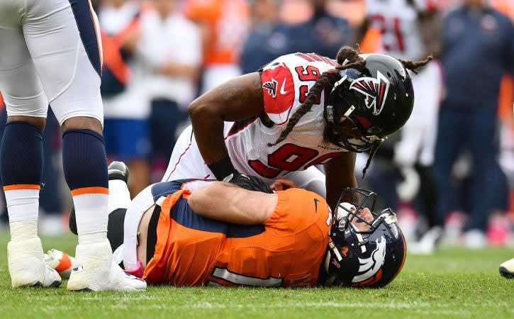 Oct 9, 2016; Denver, CO, USA; Denver Broncos quarterback Paxton Lynch (12) is tackled to the turf by Atlanta Falcons defensive end Adrian Clayborn (99) in the second half at Sports Authority Field at Mile High. The Falcons defeated the Broncos 23-16. Mandatory Credit: Ron Chenoy-USA TODAY Sports