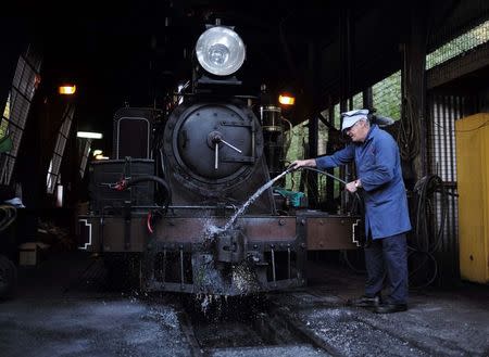 Puffing Billy steam engine fireman Barry Rogers, 70, washes locomotive 12A in the shed after hauling a train to Belgrave near Melbourne, October 20, 2014. REUTERS/Jason Reed
