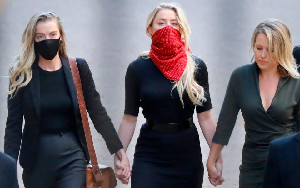 Amber Heard, (centre), American actress and former wife of Hollywood actor Johnny Depp arrives holding hands with two women - Tolga Akmen/AFP