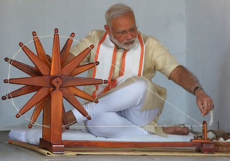 India's Prime Minister Narendra Modi spins cotton on a wheel during his visit to Gandhi Ashram in Ahmedabad, India, June 29, 2017. REUTERS/Amit Dave