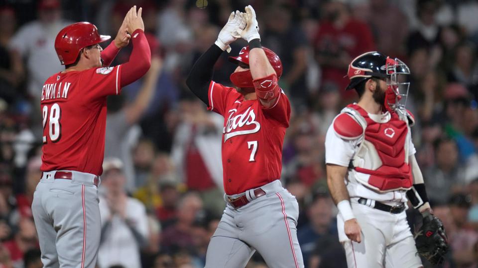 Cincinnati Reds'  Spencer Steer (7) crosses home plate and celebrates with Kevin Newman (28) after his two-run home run against the Boston Red Sox during the seventh inning of a baseball game at Fenway Park, Wednesday, May 31, 2023, in Boston.  At right is Red Sox catcher Connor Wong.