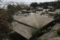 A roof covered with volcanic ash shows a sign "help" at a lakeshore village beside Taal volcano where residents have evacuated to safer ground in Agoncillo, Batangas province, southern Philippines on Saturday Jan. 18, 2020. The Taal volcano near the Philippine capital emitted more ash clouds Saturday, posing the threat of another eruption. (AP Photo/Aaron Favila)