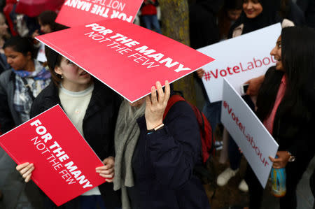 FILE PHOTO: Supporters of Britain's opposition Labour party use placards to shelter from the rain as they campaign in London, Britain, May 18, 2017. REUTERS/Neil Hall