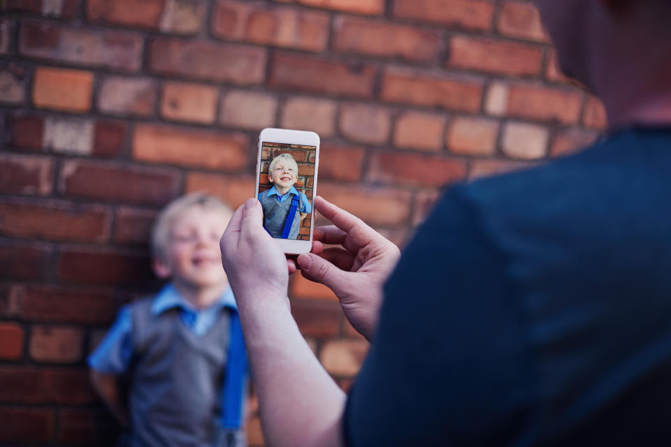 Someone using a cellphone to take a photo of their child