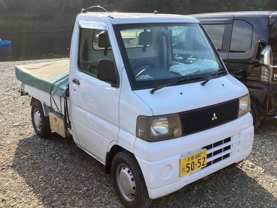 A Mitsubishi Minicab truck parked by a river in Japan