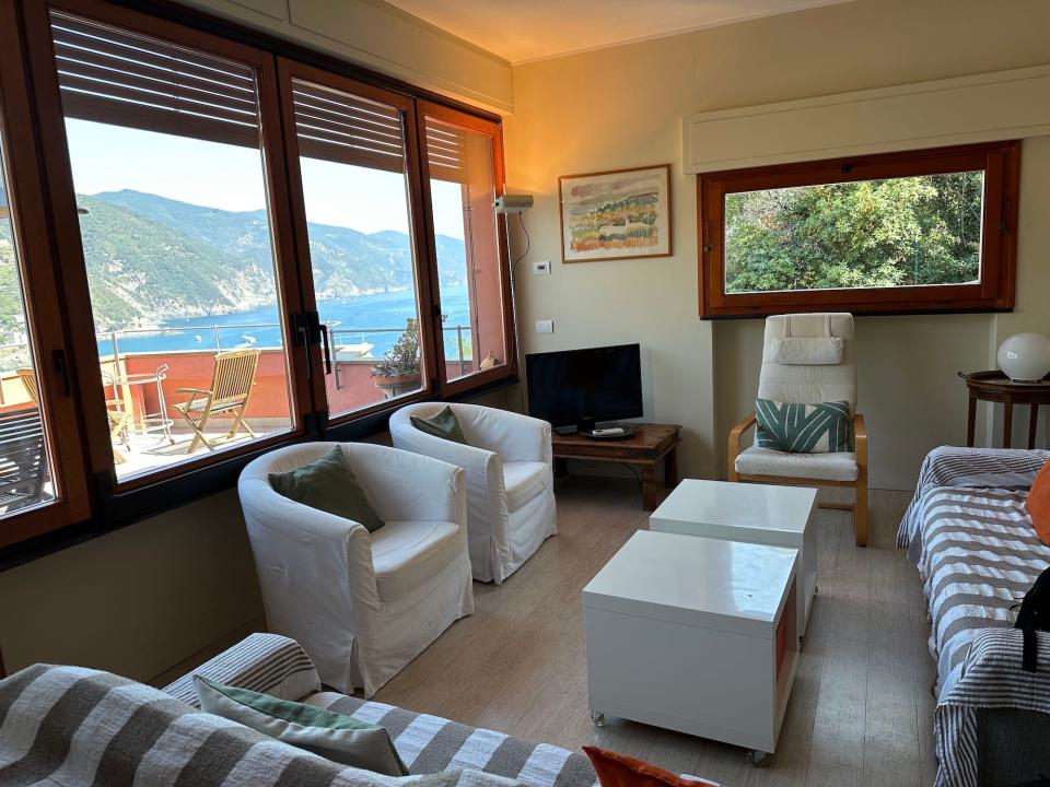 A living room with big windows that overlook the ocean.