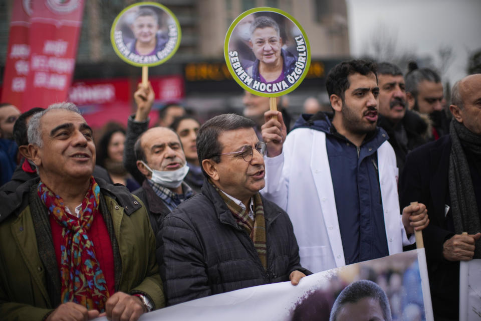 People hold up photographs of Turkish Medical Association President Dr. Sebnem Korur Fincanci, that read in Turkish: "Freedom for Sebnem", during a small rally in her support outside the Justice court in Istanbul, Turkey, Wednesday, Jan. 11, 2023. A court convicted the president of the Turkish Medical Association on Wednesday of disseminating "terror organization propaganda" following a trial that human rights groups had denounced as an attempt to silence government critics. (AP Photo/Francisco Seco)