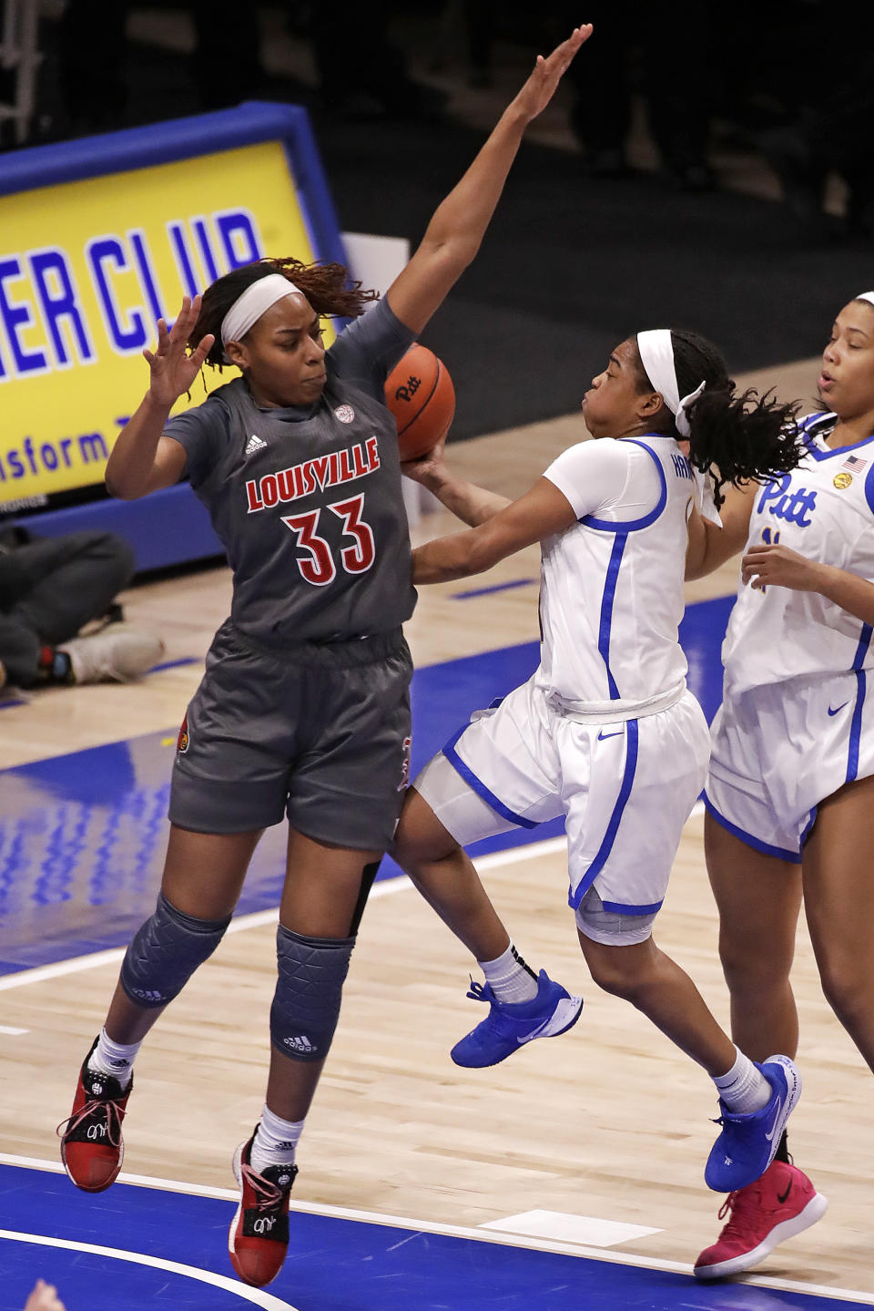 Pittsburgh's Dayshanette Harris, center, gets off a shot for a basket with Louisville's Bionca Dunham (33) defending during the first half of an NCAA college basketball game in Pittsburgh, Sunday, Feb. 23, 2020. (AP Photo/Gene J. Puskar)