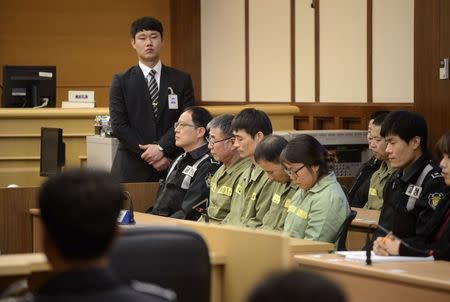 Sewol ferry captain Lee Joon-seok (3rd R) sits with crew members at the start of the verdict proceedings in a court room in Gwangju November 11, 2014. REUTERS/Ed Jones/Pool