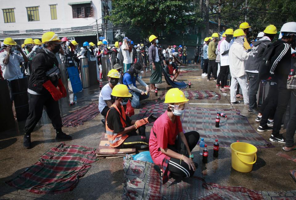 Protesters with helmet and wet cloths ready to put off tear gas gather during a demonstration in YangonAP