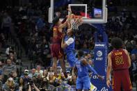 Cleveland Cavaliers guard Isaac Okoro (35) dunks over Dallas Mavericks center Moses Brown (9) as Mavericks' Tim Hardaway Jr. (11) and Cavaliers' Jarrett Allen (31) look on in the first half of an NBA basketball game in Dallas, Monday, Nov. 29, 2021. (AP Photo/Tony Gutierrez)