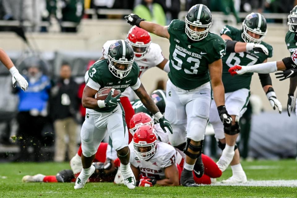 Michigan State's Jarek Broussard runs for a gain past teammate Brandon Baldwin (53) against Rutgers during the first quarter on Saturday, Nov. 12, 2022, in East Lansing.