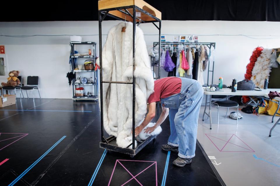 A stagehand hangs a faux fur prop after a rehearsal for the stage production of La Cage aux Folles, at the Avon Theatre in Stratford, Ont.