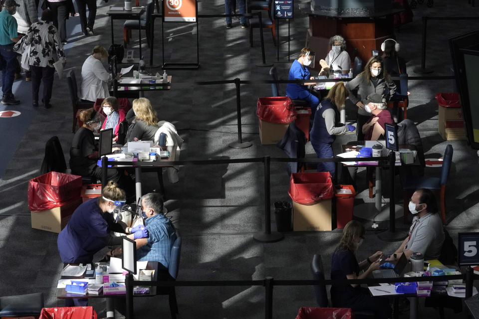 FILE - In this Feb. 11, 2021, file photo, people are administered COVID-19 vaccines at a vaccination center, at Gillette Stadium, in Foxborough, Mass. The U.S. death toll from COVID-19 has almost topped 500,000 — a number so staggering that a top health researchers says it is hard to imagine an American who hasn't lost a relative or doesn't know someone who died. (AP Photo/Steven Senne, File)