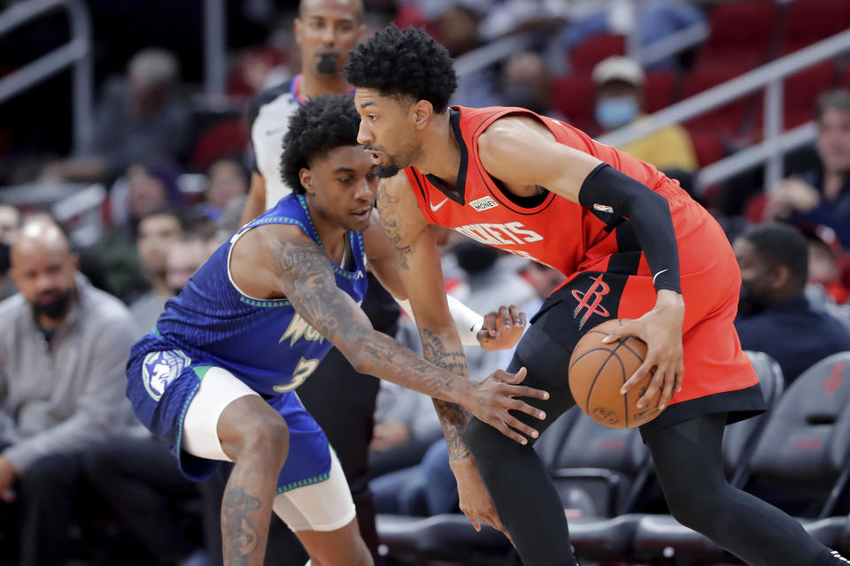 Houston Rockets center Christian Wood, right, drives past Minnesota Timberwolves forward Jaden McDaniels (3) during the first half of an NBA basketball game Sunday, Jan. 9, 2022, in Houston. (AP Photo/Michael Wyke)