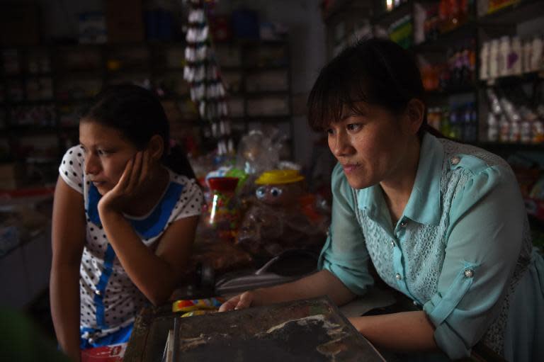 Vietnamese bride Nguyen Thi Hang (R) and fellow Vietnamese bride Vu Thi Hong Thuy in the shop where Hang works in Weijian village, China's Henan province on July 29, 2014