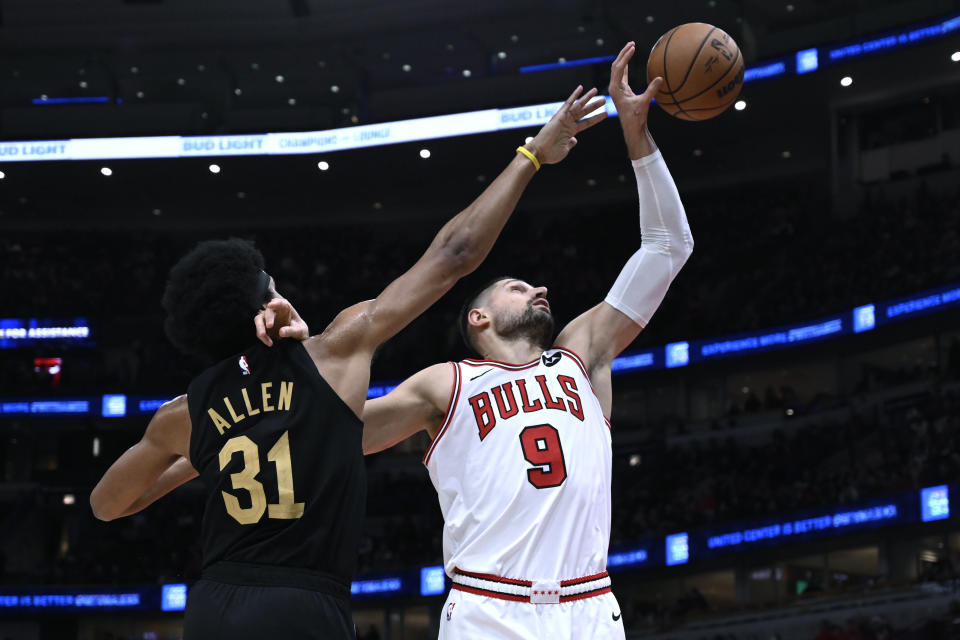 Chicago Bulls center Nikola Vucevic (9) reaches for a rebound next to Cleveland Cavaliers center Jarrett Allen (31) during the first half of an NBA basketball game, Saturday, Dec. 23, 2023, in Chicago. (AP Photo/Matt Marton)