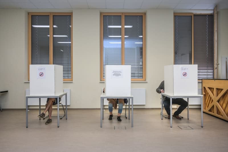 Voters sit behind polling booths at the polling station in the Rutheneum secondary school. Thuringia holds local elections for mayors, district councillors, city councillors, and municipal councillors. Heiko Rebsch/dpa