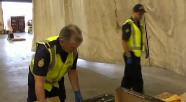 AFP officers examining the seized weapons. Photo: 7 News